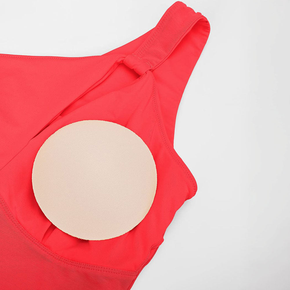 Vienpleca peldkostīms ar krokojumu vēdera zonā un sievišķīgu piegulumu, tuvplāns, polsteri